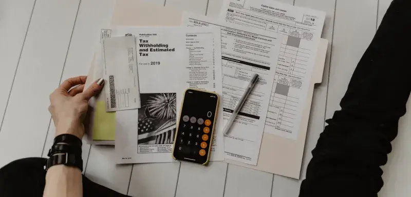 Documents comptables et calculatrice sur un bureau, symbolisant le calcul des cotisations sociales