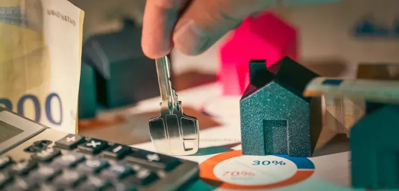 A person putting money into a calculator