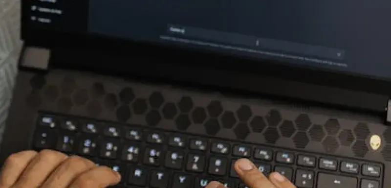 Mains tapant sur un ordinateur portable affichant l interface ChatGPT, illustrant la technologie IA