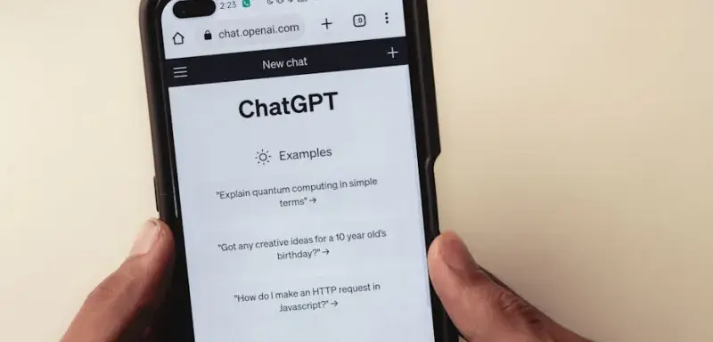 Gros plan sur des mains tenant un smartphone affichant l interface de l application ChatGPT
