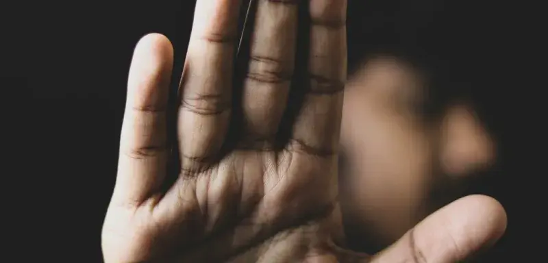 Main gauche sur fond noir, symbolisant la menace et la violence