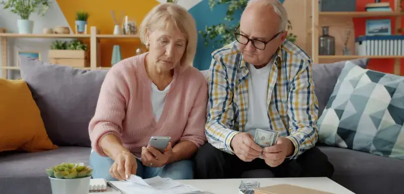 Couple examinant des documents financiers pour gérer le budget familial