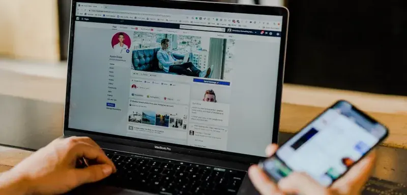 Un adolescent utilisant un ordinateur portable et un smartphone, symbole de la génération connectée ciblée par les formations en marketing digital