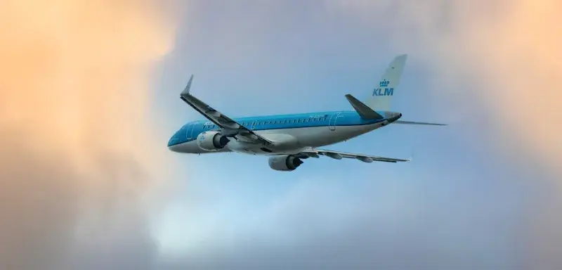 Un avion bleu et blanc volant dans un ciel nuageux