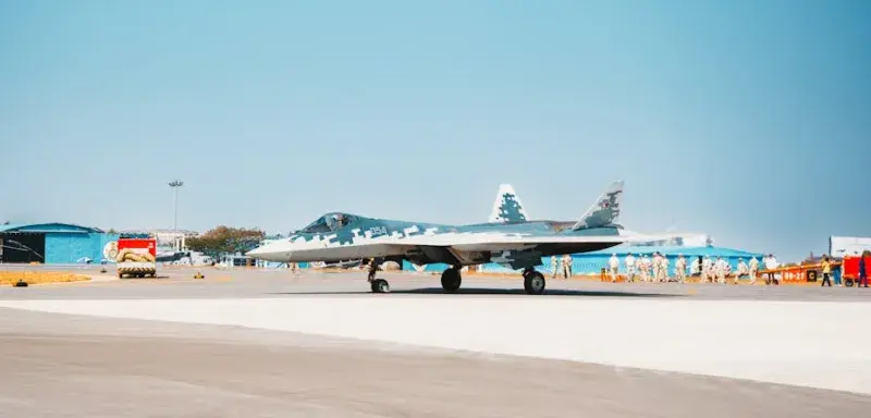 Un chasseur furtif Su-57 stationné sur une piste d'aérodrome militaire