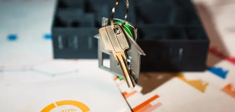 Un porte-clés en forme de maison suspendu à une clé, symbole de l'investissement immobilier locatif