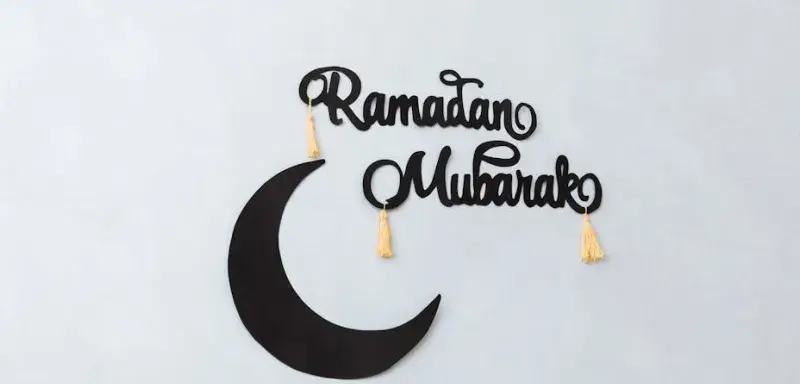 Décoration minimaliste Ramadan Mubarak avec un croissant de lune sur un mur clair