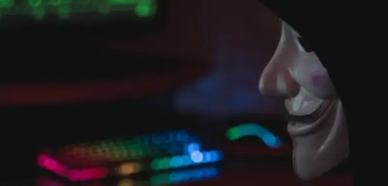 Silhouette mystérieuse devant un écran d'ordinateur symbolisant les menaces de cybersécurité