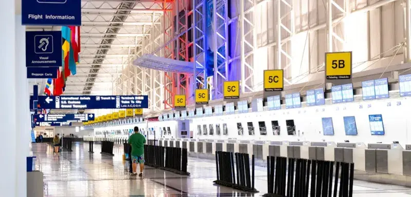 Vue panoramique d'un terminal d'aéroport avec comptoirs d'enregistrement et drapeaux
