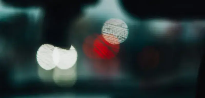 Lumières floues créant des motifs de bokeh rappelant la circulation vue de l intérieur d un véhicule la nuit
