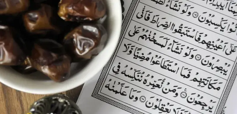 Un bol de dattes posé à côté du Coran, symbole de la tradition de l'iftar pendant le Ramadan