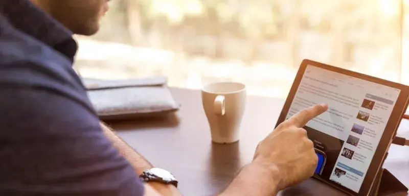 Homme consultant un profil professionnel sur une tablette numérique