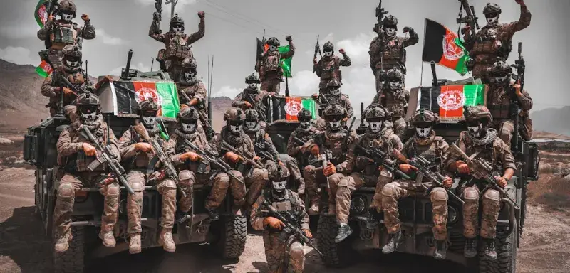 Des combattants afghans armés sur un véhicule militaire