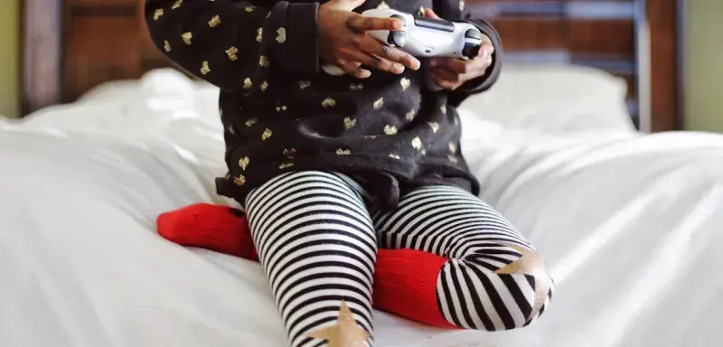 Enfant jouant aux jeux vidéo sur une manette de console