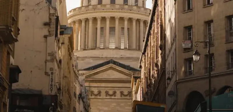 Vue saisissante du Panthéon à Paris encadré par des bâtiments historiques sous un ciel dramatique