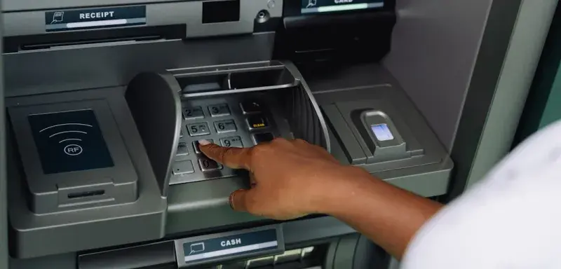 Une personne effectuant un retrait à un distributeur automatique de billets