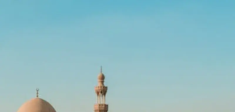 Vue d'une ancienne cour de mosquée au Caire, en Égypte, sous un ciel bleu dégagé, capturant l'architecture islamique