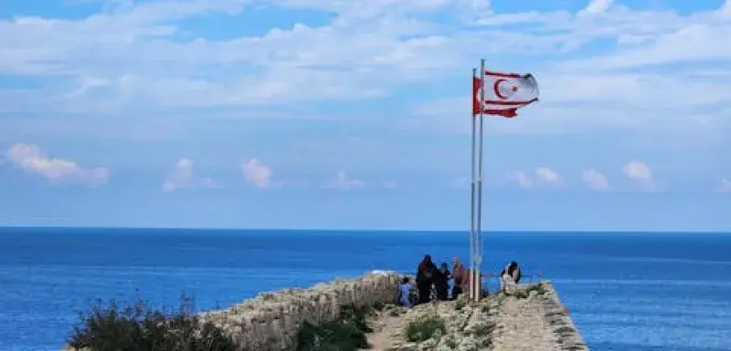 Le château historique de Kyrenia avec des drapeaux surplombant la mer par une journée ensoleillée