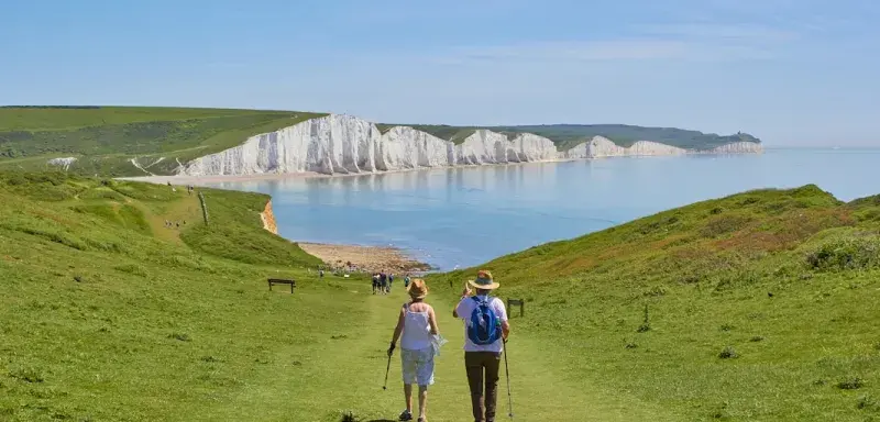 Deux hommes debout sur un terrain herbeux près d'un plan d'eau pendant la journée