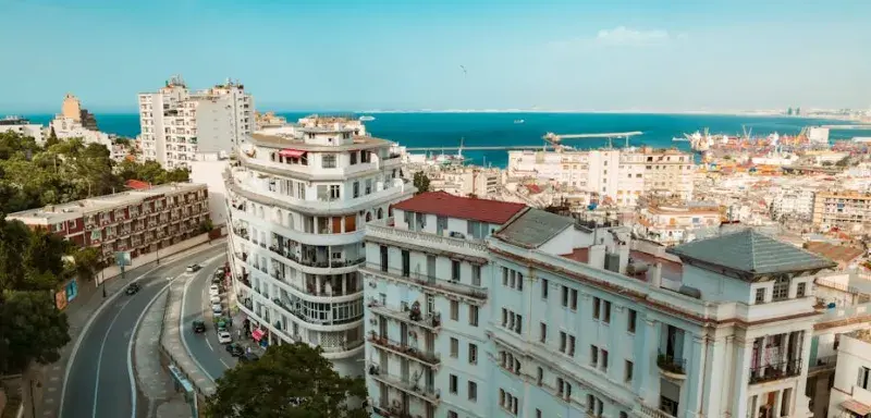 A stunning aerial view of Algiers featuring white buildings and the Mediterranean Sea.
