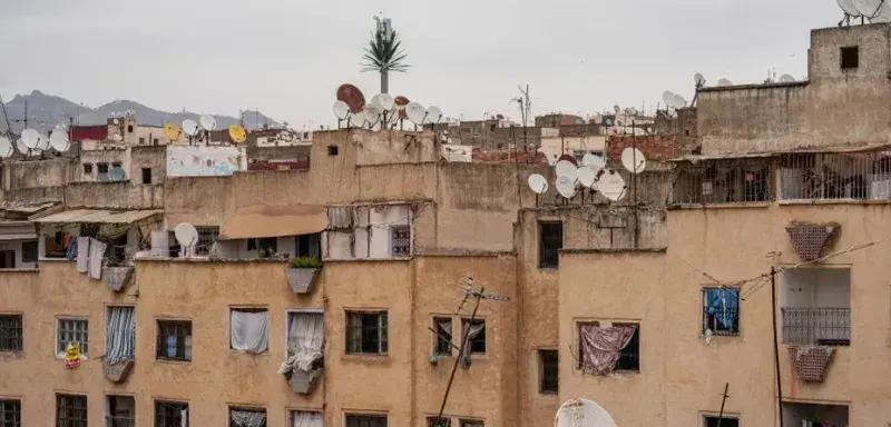 View of rooftops in Fes, Morocco, highlighting satellite dishes and urban texture.