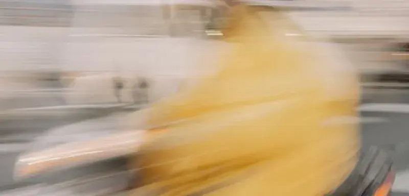 Abstract blurred image of a person riding a scooter in Kyoto, Japan.