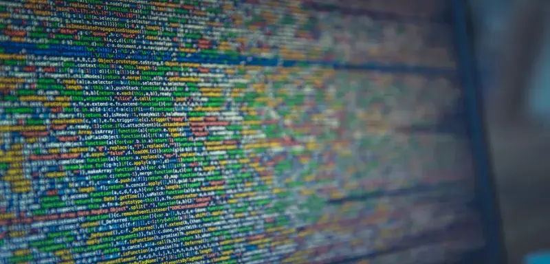 Vue rapprochee d'un code source colore affiche sur un ecran d'ordinateur, illustrant la cybersecurite et la protection des donnees.