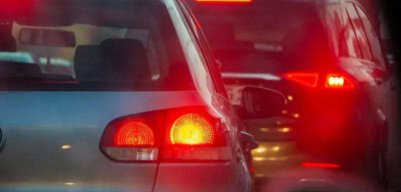 a group of cars driving down a street next to each other