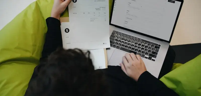 A person sitting on a bean bag chair working on a laptop