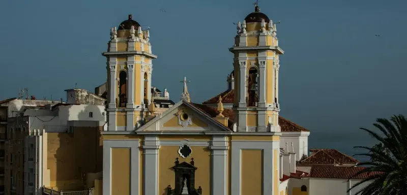 A large yellow and white building with two towers