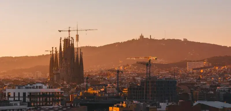 A view of a city at sunset with a mountain in the background