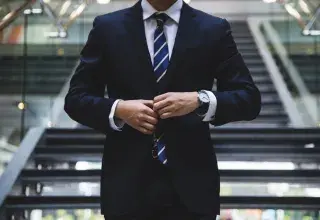 Homme en costume devant un escalier, symbolisant la recherche d'emploi