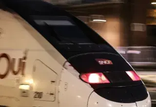 Train blanc circulant sur les rails la nuit