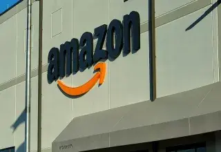 Devanture d'un magasin Amazon avec une personne assise devant