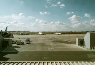 Vue du terminal et de la piste de l'aéroport avec des avions sous un ciel nuageux