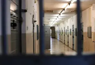 Couloir d'une prison avec des cellules verrouillées