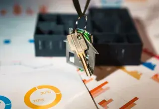 Un porte-clés en forme de maison suspendu à une clé, symbole de l'investissement immobilier locatif