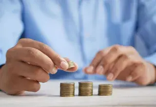 Pièces de monnaie empilées sur une table, symbolisant l'épargne immobilière