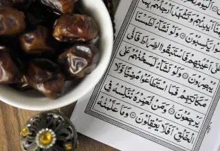 Un bol de dattes posé à côté du Coran, symbole de la tradition de l'iftar pendant le Ramadan