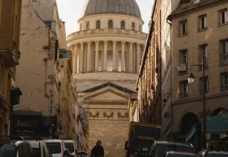 Vue saisissante du Panthéon à Paris encadré par des bâtiments historiques sous un ciel dramatique