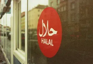Panneau halal rouge et blanc dans un commerce alimentaire