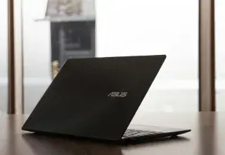 un ordinateur portable posé sur une table en bois