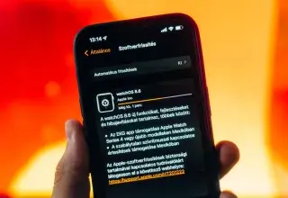 Une main tenant un iPhone affichant une mise à jour système