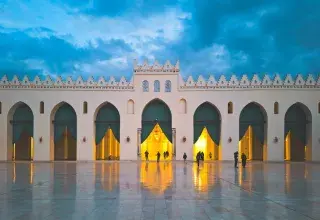 Vue nocturne de la mosquée Al-Hakim au Caire illuminée, symbolisant la spiritualité du mois de Ramadan