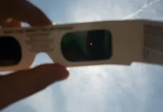 person's hand holding white 3D sunglasses