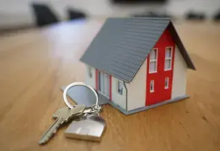 white and red wooden house miniature on brown table