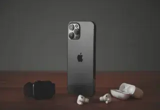 Un smartphone, une montre connectée et des écouteurs sans fil Apple sur une surface en bois